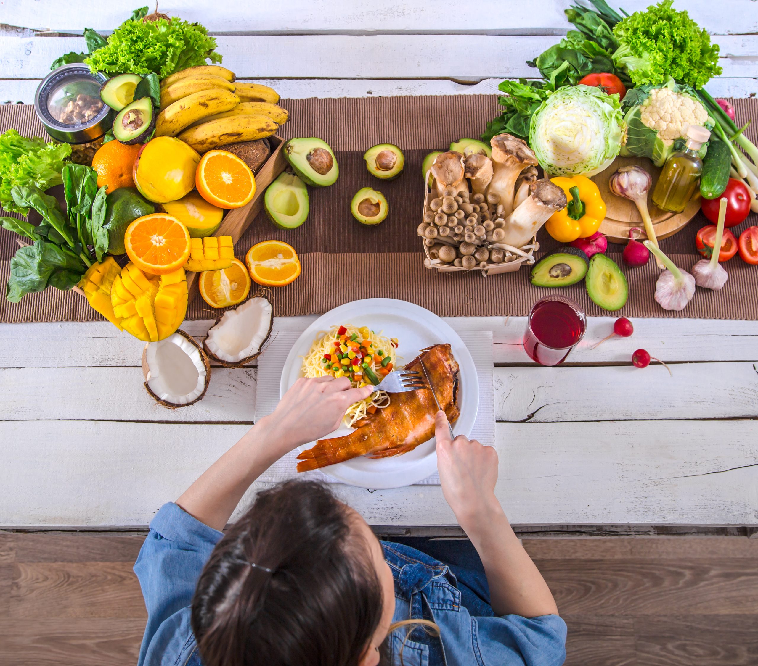 The woman at the dinner table with organic food , the view from the top.